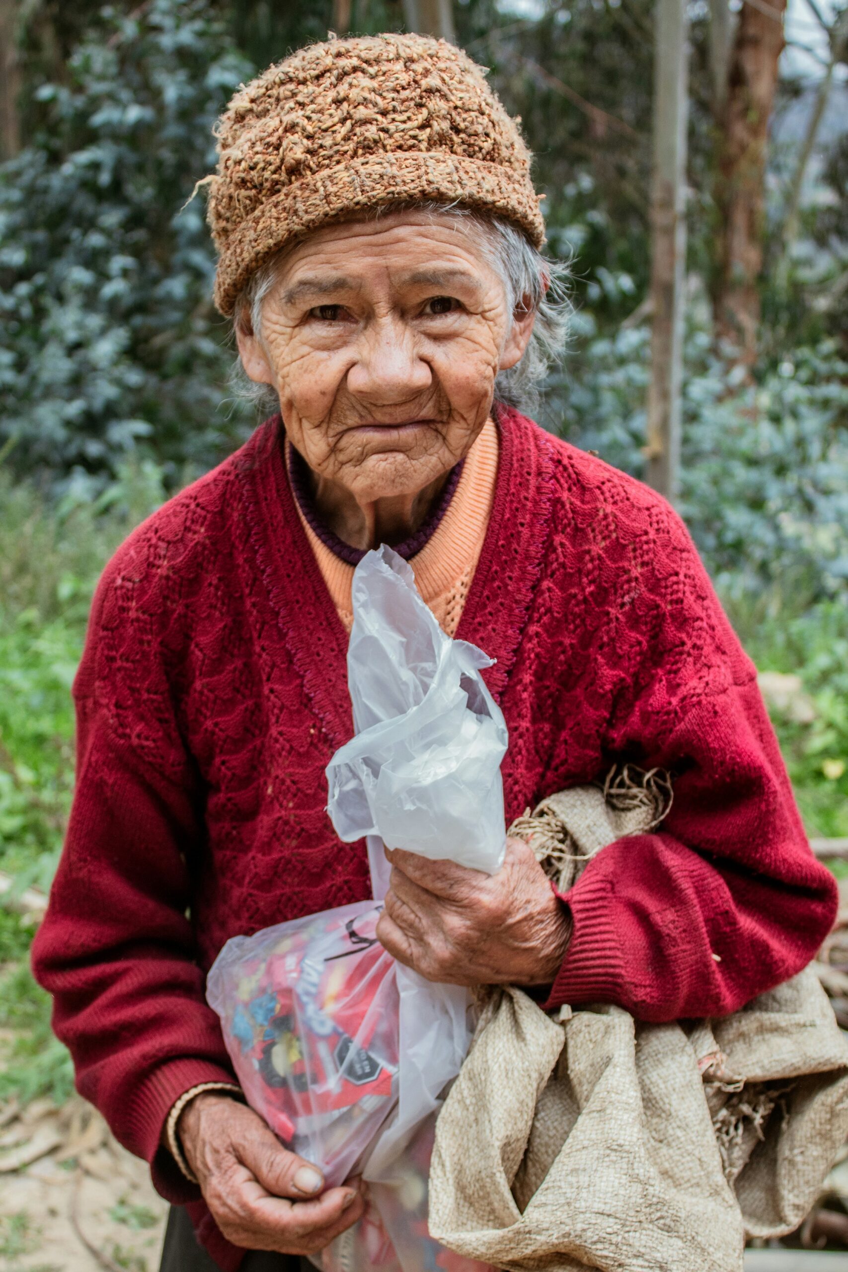 a woman in a red sweater holding a bag of food